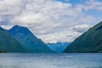 blue mountain lake with green mountains blue sky and white clouds