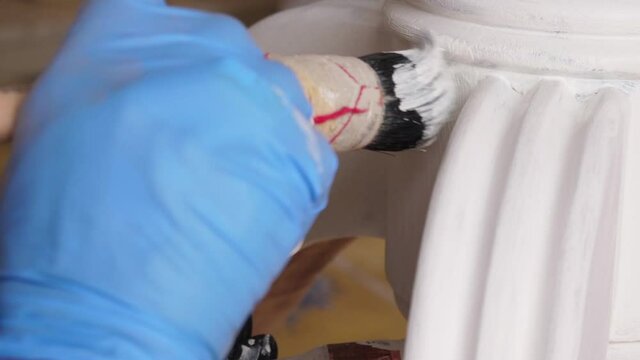 painting with brush to restore old wooden furniture slow motion