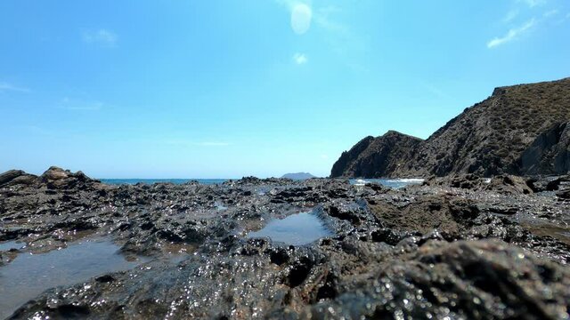 View of Ba&ntilde;o de las Mujeres beach in Lorca, Spain. Waves crashing into the seashore.