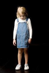 Full Length Portrait of Cute Blonde Girl Standing and Looking Down.