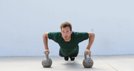 Fitness gym man doing pushups workout holding kettlebells for full extended push-ups floor exercises at outdoor gym. Athlete working out with bodyweight exercise. - Powered by Adobe
