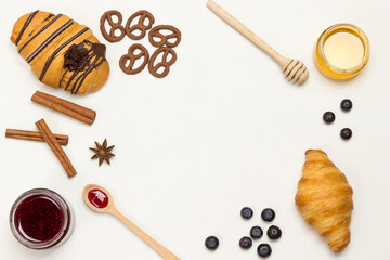 Croissants and figured cookies, berries, apricots honey, jam, cinnamon. Set of products for nutritious breakfast.