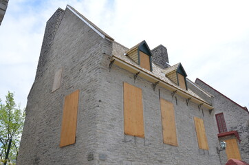 Fototapeta na wymiar grey brick building with boarded up windows