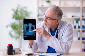 Old male doctor radiologist in telehealth concept