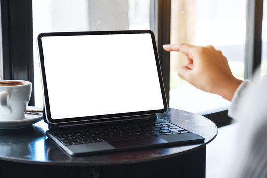 Mockup image of a woman using and pointing finger at tablet pc with blank desktop white screen as a computer pc