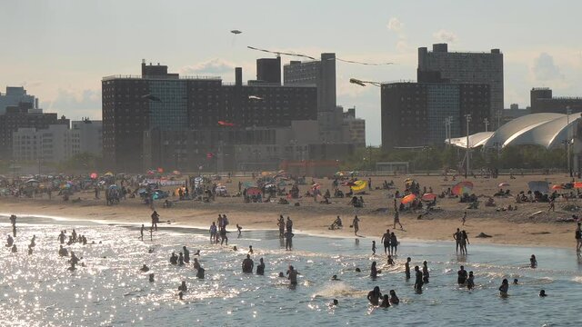 blurry image , unrecognized people at beach ,beach and building skyline of coney island beach NY