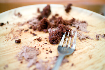 close up leftovers piece of cake on wooden plate