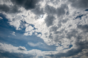 A huge cumulus cloud and many small clouds on a blue sky. Nature background