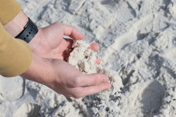  A hand full of flowing white sand on my hands. Summertime spent in the beach.