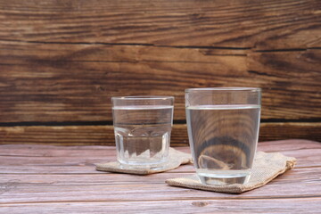 Glasses of water on a wooden table background and space for text