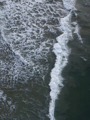 Fototapeta na wymiar Aerial photo of small waves breaking. Taken off the coast of a small surf town in beautiful New Zealand. 
