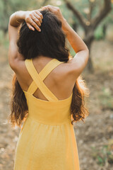 Woman in yellow summer linen dress. Closeup detail of back. View from behind. Trendy outfit style