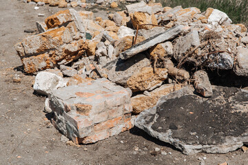 Old construction waste. Reinforcement sticks out of a pile of brick, stone and concrete waste....