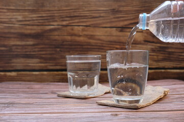 Glasses of water on a wooden table background and space for text