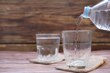 pouring water into glass on wood table 