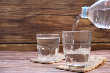 Drinking water on wooden table background and space for text 