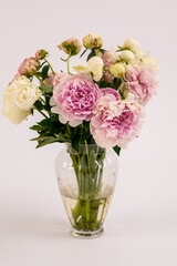 Lovely flowers in glass vase. Beautiful bouquet of pink peonies . Floral composition, scene, daylight. Wallpaper isolated