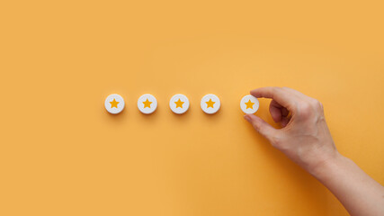 Positive rating in the form of five stars. The hand of a man puts up stars. Rating in social...