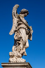 Fototapeta na wymiar Statue of a monument to an angel on a background of blue sky.
