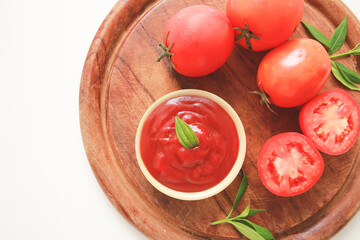 Bowl of ketchup or tomatoes sauce with ingredients on wooden plate.