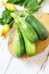 Fresh healthy uncooked green zucchini on a wooden kitchen table. Diet menu concept. Copy space.