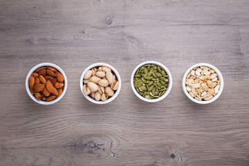 Mix Nuts in the glass on wooden background close up , peanut peas seeds pumpkin seeds , pistachios