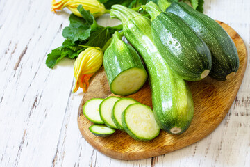 Fresh healthy uncooked green zucchini on a wooden kitchen table. Diet menu concept. Copy space.