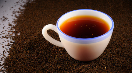 Obraz na płótnie Canvas Cup of tea with and black tea leaves
