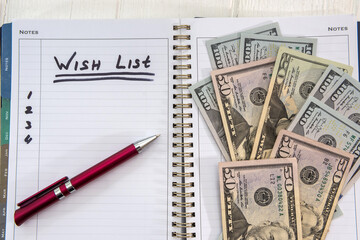 text wish list  on notepad with dollar bills
