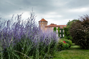 Brick round tower of Wawel castle residency in park landscape in Krakow, Poland