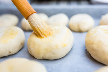 Applying glaze to homemade butter buns.