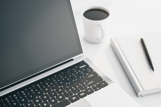 Close up of modern laptop with cup of coffee on white table. 3D Rendering