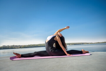 Pretty woman do the splits. morning warming-up near lake. sport active lifestyle concept