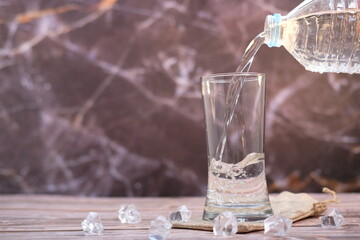 Pouring drinking water on wooden table background and space for text 