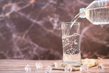 Pouring drinking water on wooden table background and space for text 