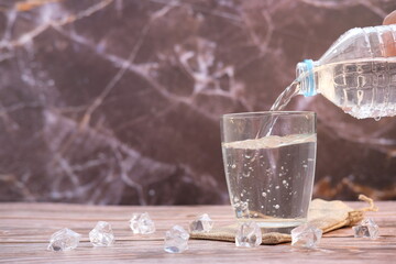 pouring drinking water on wooden table background and space for text 