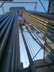 Obraz premium The internal structure of the drilling rig. Top power drive of drilling rig, equipment for lowering and lifting pipes. Drill pipes installed vertically.