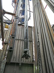 The internal structure of the drilling rig. Top power drive of drilling rig, equipment for lowering and lifting pipes. Drill pipes installed vertically.