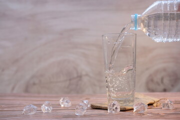 pouring drinking water on wooden table background and space for text 