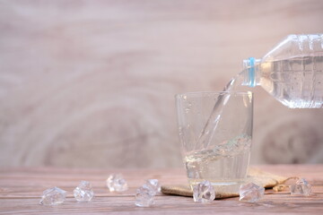 Drink water pouring into glass on wood table and space for text