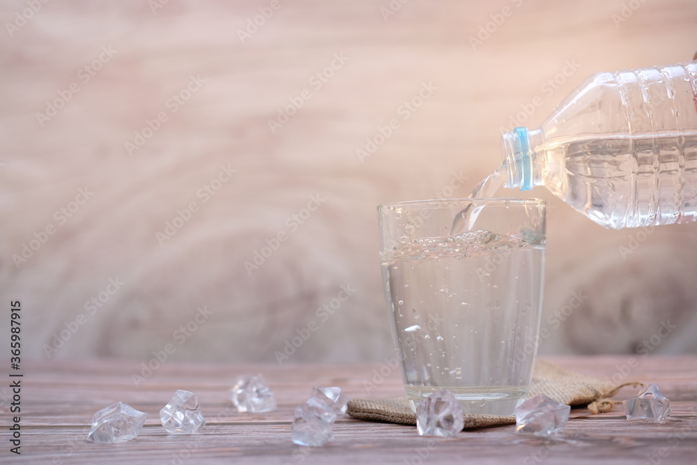 Poster pouring drinking water on wooden table background and space for text 