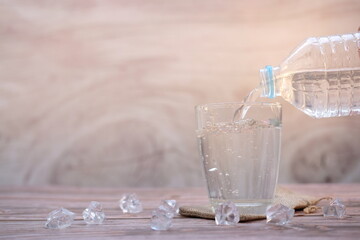 pouring drinking water on wooden table background and space for text 
