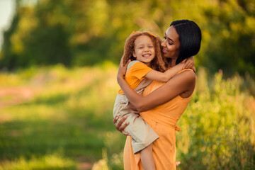 International family: happy cheerful mother and daughter on a summer walk in the park