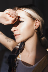 Portrait authentic blonde young woman posing with painting tools. Inspiring beauty concept. Art therapy. Light play and shadow concept.