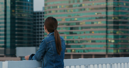 Woman looks at city view