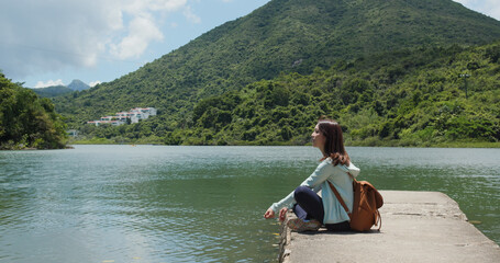 Fototapeta na wymiar Woman with backpack looks around the mountain and sea view