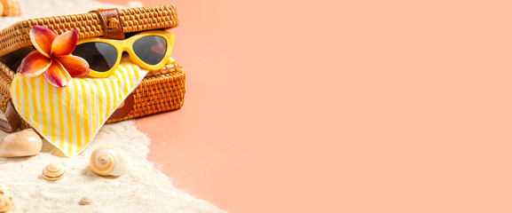 summer sand beach with wicker bag and sunglasses on peach vintage color background.vacation banner...