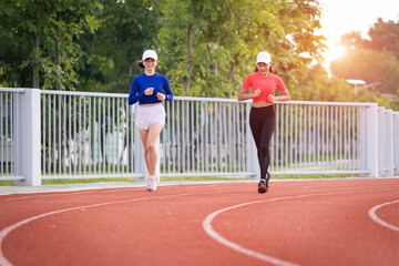 Obraz premium Young fitness woman runner jogging excercise in the morning on city stadium track in the city. Female athlete excercise in the city stadium to keep body fitness. Stock photo.