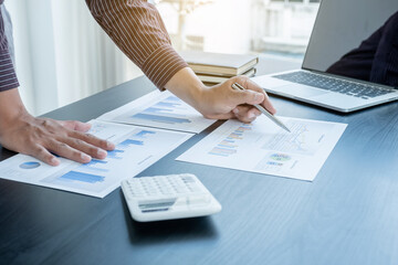 The hands of a male businessman are analyzing and calculating the annual income and expenses in a...