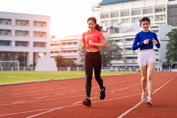 Fototapeta premium Young fitness woman runner jogging excercise in the morning on city stadium track in the city. Female athlete excercise in the city stadium to keep body fitness. Stock photo.